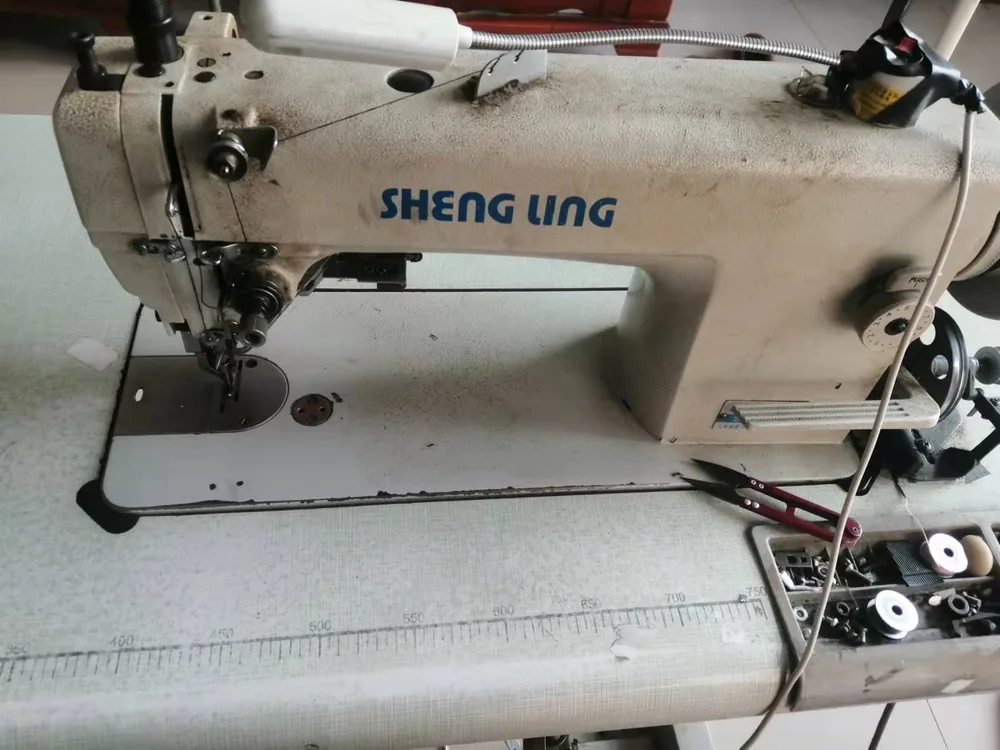 Sewing machine operator working on a bag panel in our Baigou workshop