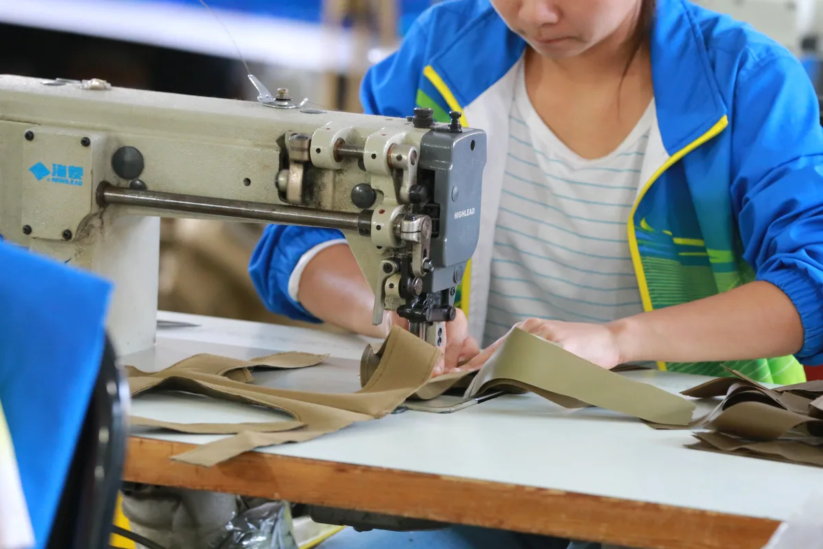 Close-up of a worker stitching a bag panel at our sewing line